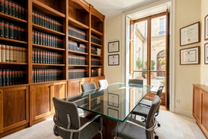 Intérieur d'un cabinet d'avocat moderne à Nîmes avec bibliothèque juridique et table de réunion en verre
