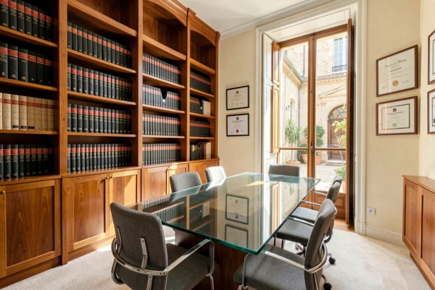 Intérieur d'un cabinet d'avocat moderne à Nîmes avec bibliothèque juridique et table de réunion en verre